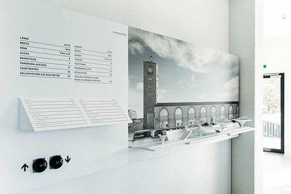 Modernes weißes Display mit s/w-Foto von Uhrturm, Bahnhof, Infotext, Buttons und Modellen.