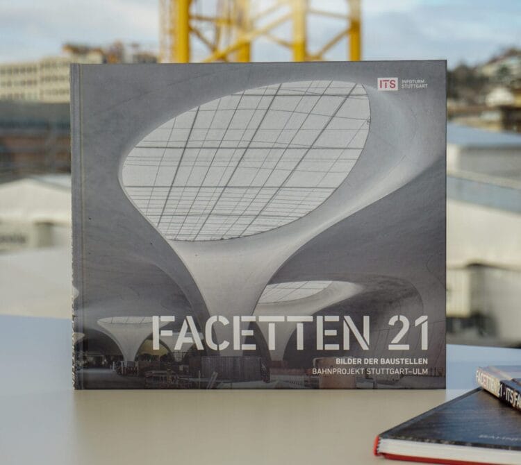 Buch "FACETTEN 21" mit moderner Decke auf dem Einband, auf dem Tisch, Konstruktion außerhalb des Fensters sichtbar.