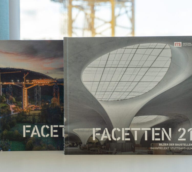 Zwei "FACETTEN 21"-Bücher auf einem Tisch, die Umschläge zeigen Szenen aus dem Bauwesen und der modernen Architektur.